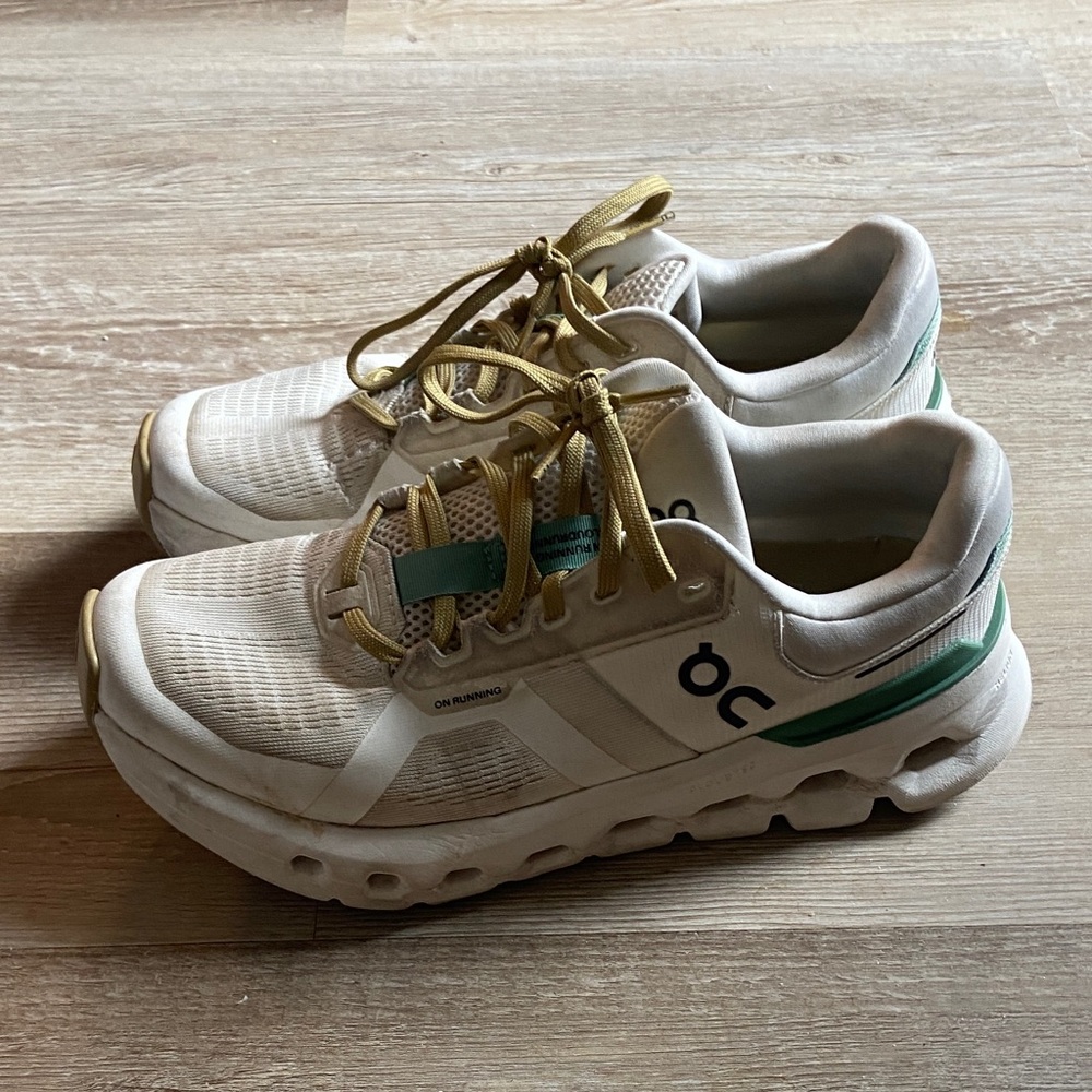 On Running Sneakers with White, Green, and Gold Accents